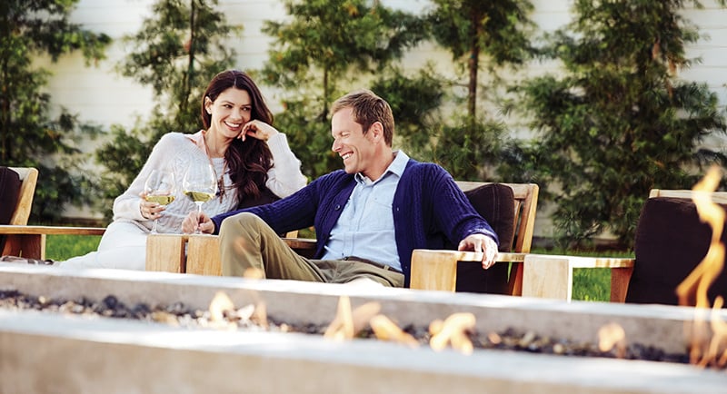 Couple smiling and enjoying wine, reflecting the relaxed luxury of life at The Ritz-Carlton Residences, Estero Bay